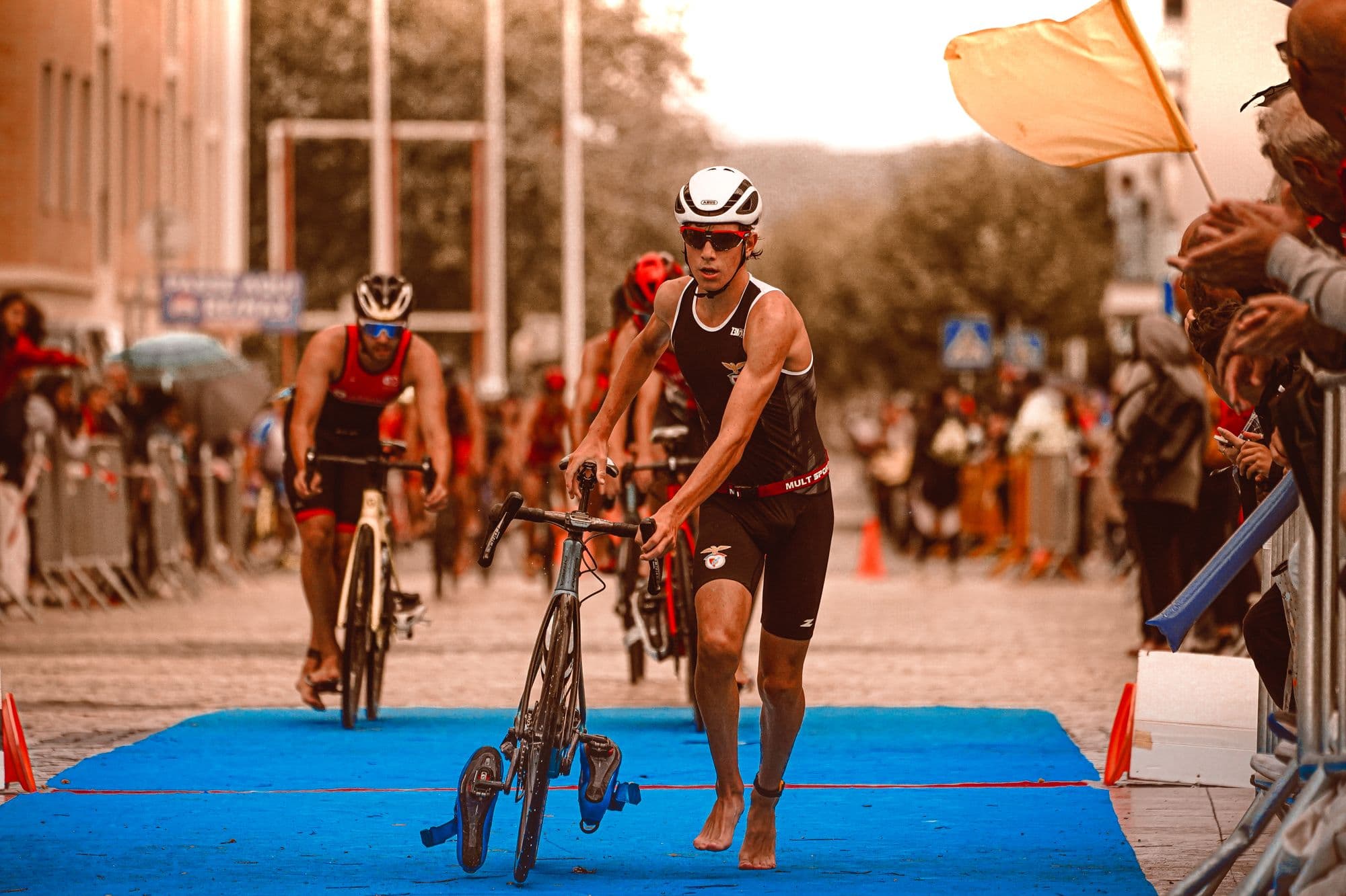Atlet triathlon membawa sepeda saat perlombaan